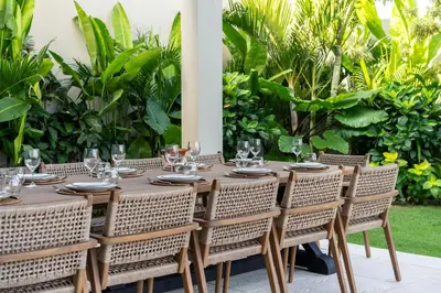 a wooden table with chairs and wine glasses on it at Villa Charleston Umalas in Kerobokan