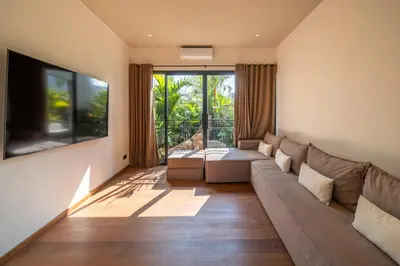 a living room with a couch and a large window at Villa Charleston Umalas in Kerobokan