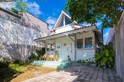 a small white house with a dog sitting on the porch at SooBali Mint Cottage Sanur 1BR in Sanur