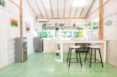 a kitchen with a counter and stools in it at SooBali Mint Cottage Sanur 1BR in Sanur
