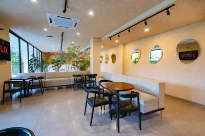 a restaurant with tables and chairs and a bench at Sunny Nine Villa by Betterplace in Canggu