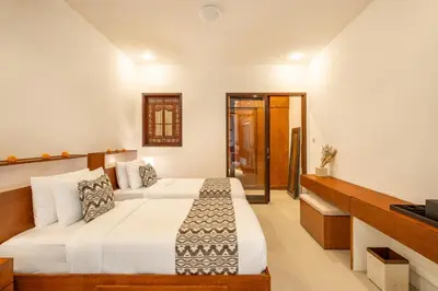 a hotel room with two beds and a television at Seven Residence in Seminyak