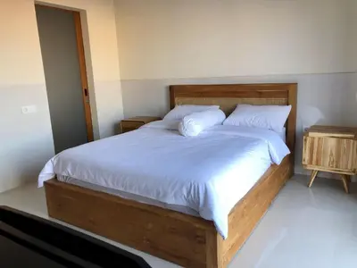 a bedroom with a large bed with white sheets and pillows at Surya Homestay in Seminyak