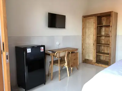 a kitchen with a small table and a black refrigerator at Surya Homestay in Seminyak