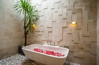a bath tub in a bathroom with a palm tree at Villa Annecy in Seminyak