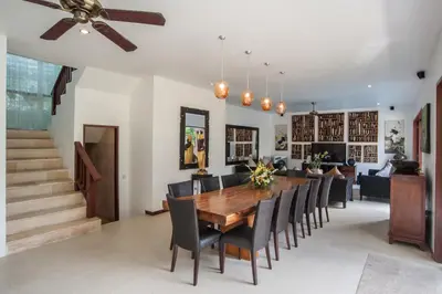 a dining room with a wooden table and chairs at Villa Annecy in Seminyak