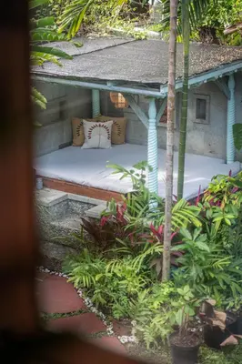 a bed in a garden with plants at Jungle Wave Villa in Central Seminyak in Seminyak