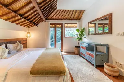 a bedroom with a large bed and a television at Jungle Wave Villa in Central Seminyak in Seminyak