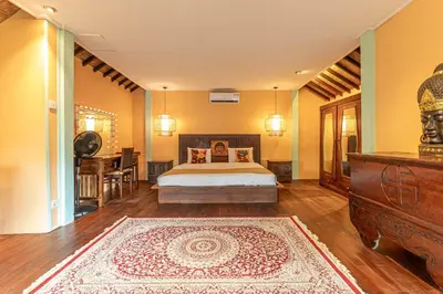 a bedroom with a bed and a dresser and a table at Jungle Wave Villa in Central Seminyak in Seminyak