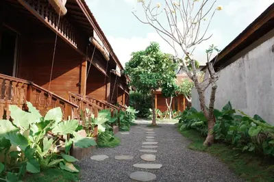 a garden with a walkway next to a building at The Riang Villa in Kerobokan