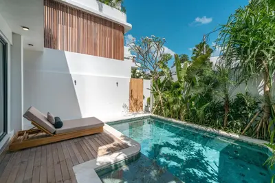 a swimming pool with a bench next to a house at Villa Moana - Incredible 2BR Villa Next To The Beach in Canggu in Canggu