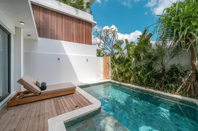 a swimming pool with a bench next to a house at Villa Moana - Incredible 2BR Villa Next To The Beach in Canggu in Canggu