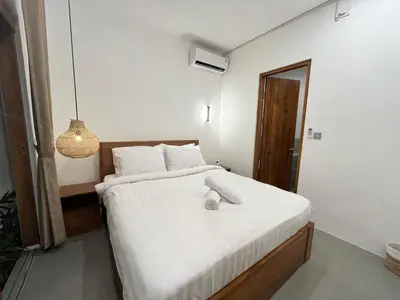 a bedroom with a large bed with white sheets at Della Rossa in Seminyak