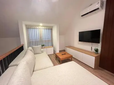 a bedroom with two beds and a flat screen tv at Della Rossa in Seminyak