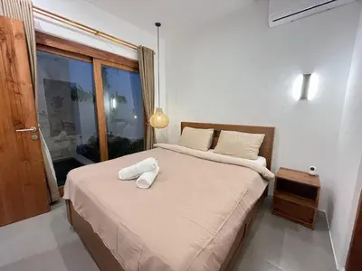 a bedroom with a bed with two towels on it at Della Rossa in Seminyak