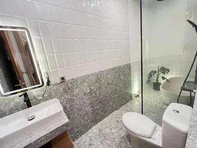 a bathroom with a toilet and a sink and a tub at Della Rossa in Seminyak