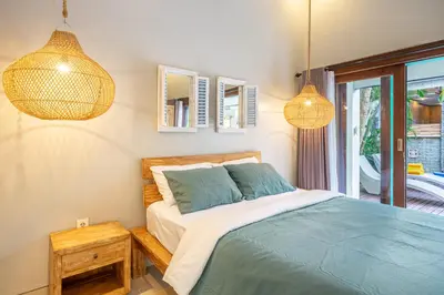 a bedroom with a bed and two lamps and a window at Q LO 1 , Seminyak in Seminyak