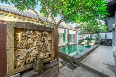 a wooden wall next to a house with a swimming pool at Q LO 1 , Seminyak in Seminyak