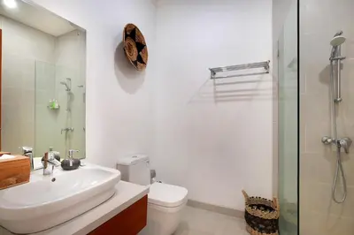 a bathroom with a sink and a toilet and a shower at Villa Indaros in Seminyak