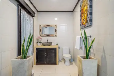 a bathroom with a sink and a toilet and a mirror at QLO Villa , Seminyak in Seminyak