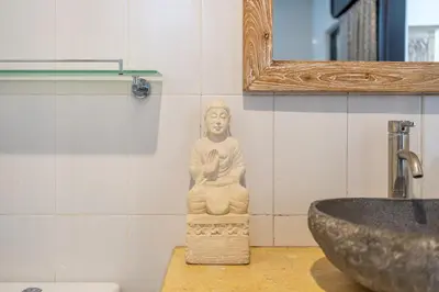 a bathroom with a statue next to a sink at QLO Villa , Seminyak in Seminyak