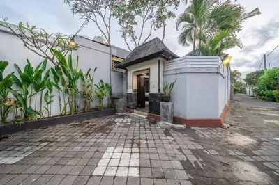 a white house with a courtyard and trees at QLO Villa , Seminyak in Seminyak