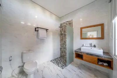 a white bathroom with a sink and a toilet at Q LA Villas in Seminyak
