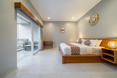a bedroom with a bed and a balcony at Q LA Villas in Seminyak