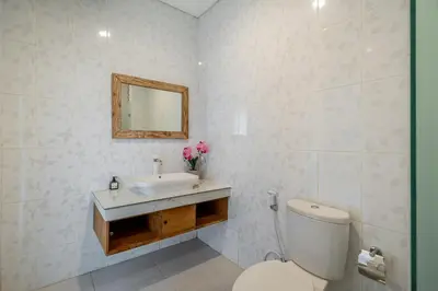 a bathroom with a white toilet and a sink at Q LA Villas in Seminyak