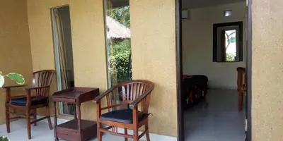 a mirror in a room with two chairs and a table at Vico hotel in Nusa Dua