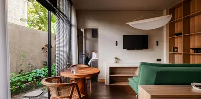 a living room with a green couch and a table at Aviator Bali in Canggu