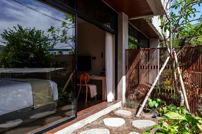 an external view of a house with a garden and a patio at Aviator Bali in Canggu