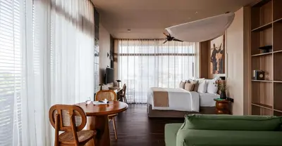a bedroom with a bed and a table and a couch at Aviator Bali in Canggu