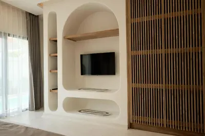 a living room with a tv on a wall at Armonia Bali Legian Villas in Legian