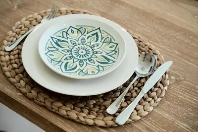 a bowl and a plate with a mandala on a table at Armonia Bali Legian Villas in Legian
