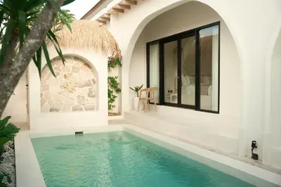 a swimming pool in a villa with a house at Armonia Bali Legian Villas in Legian