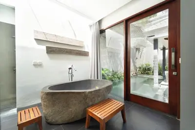 a bathroom with a large tub and a window at The Black Pearl - The Best 1br Villa In Seminyak in Seminyak