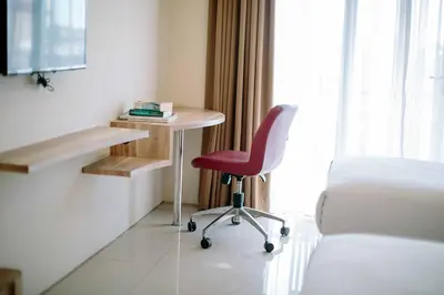 a room with a desk and a chair and a bed at Mahogany Hotel in Nusa Dua