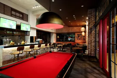 a pool table in a restaurant with a bar at Mahogany Hotel in Nusa Dua