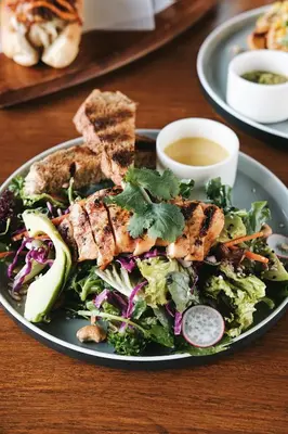 a plate of food with a salad on a table at Mahogany Hotel in Nusa Dua