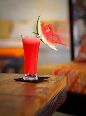 a drink sitting on a table with a slice of watermelon at Kubu Cempaka Seminyak in Seminyak