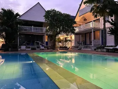 a swimming pool in front of a house at Kenzo hut3 mesari in Seminyak