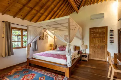 a bedroom with a canopy bed in a room at Villa Tago - 5 BR Villa in Umalas in Kerobokan