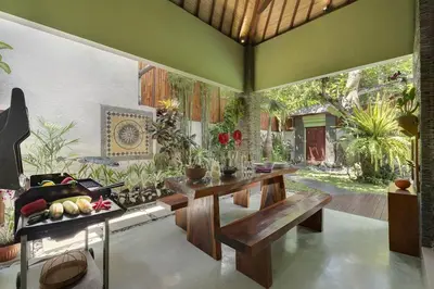 a living room with a table and a bench at ViLLA GREEN MANGO SEMINYAK BALI in Seminyak