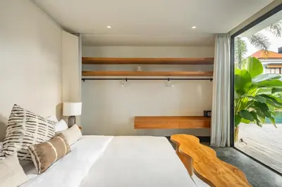 a bedroom with a white bed and a window at The Fernweh Umalas in Canggu