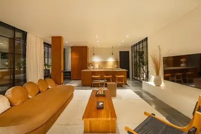 a living room with a couch and a kitchen at The Fernweh Umalas in Canggu