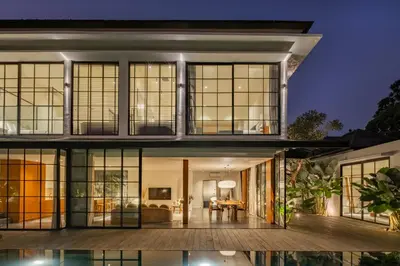 a home with large windows and a living room at The Fernweh Umalas in Canggu