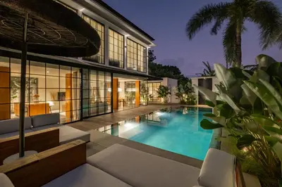 an exterior view of a house with a swimming pool at The Fernweh Umalas in Canggu