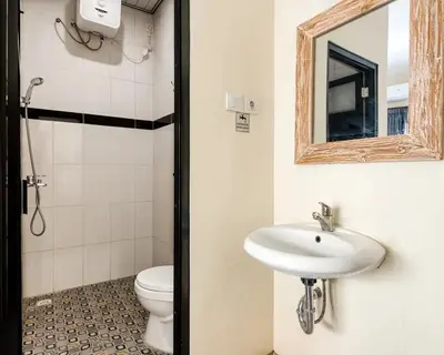 a bathroom with a toilet and a sink and a mirror at Dhita Kubu in Kerobokan