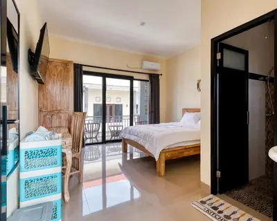 a bedroom with a bed and a balcony at Dhita Kubu in Kerobokan
